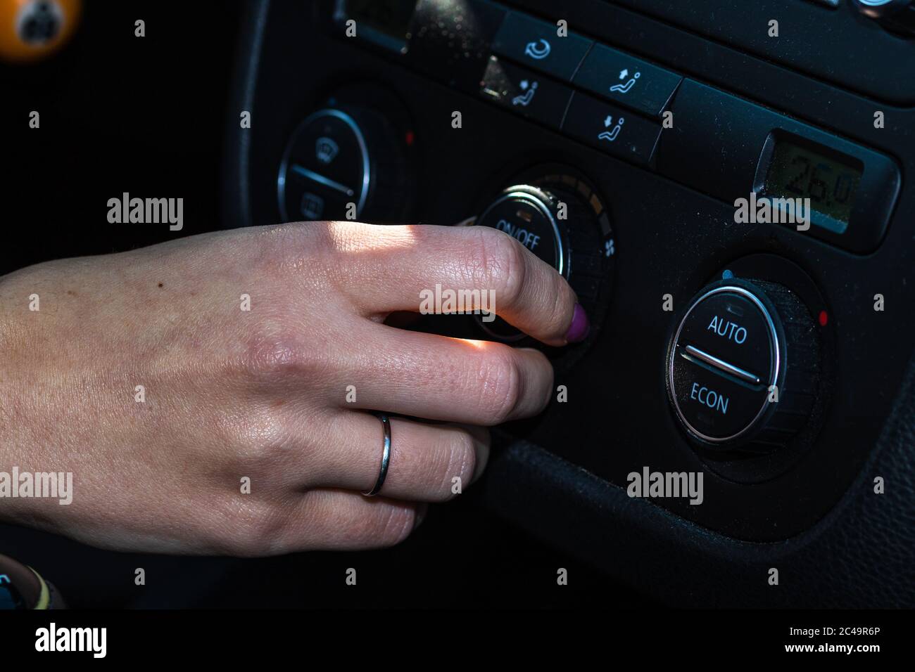 Driver`s hand using control buttons of modern car. Woman adjusting air